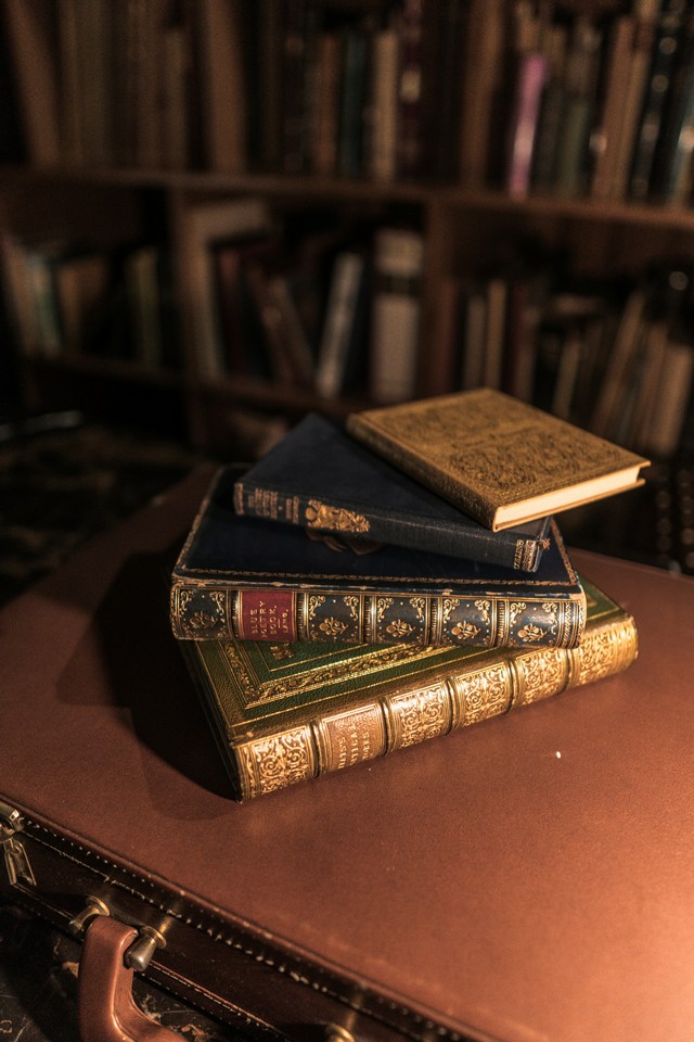 a stack of brown leather-bound books on a wooden table