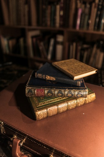 a stack of brown leather-bound books on a wooden table